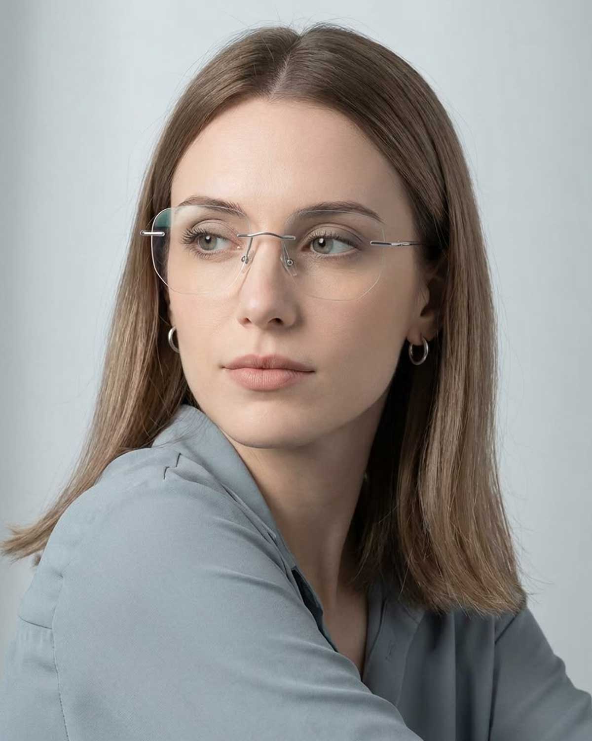 A woman wearing ultra-lightweight rimless titanium eyeglasses, showcasing a comfortable, fatigue-free fit for long hours of wear.