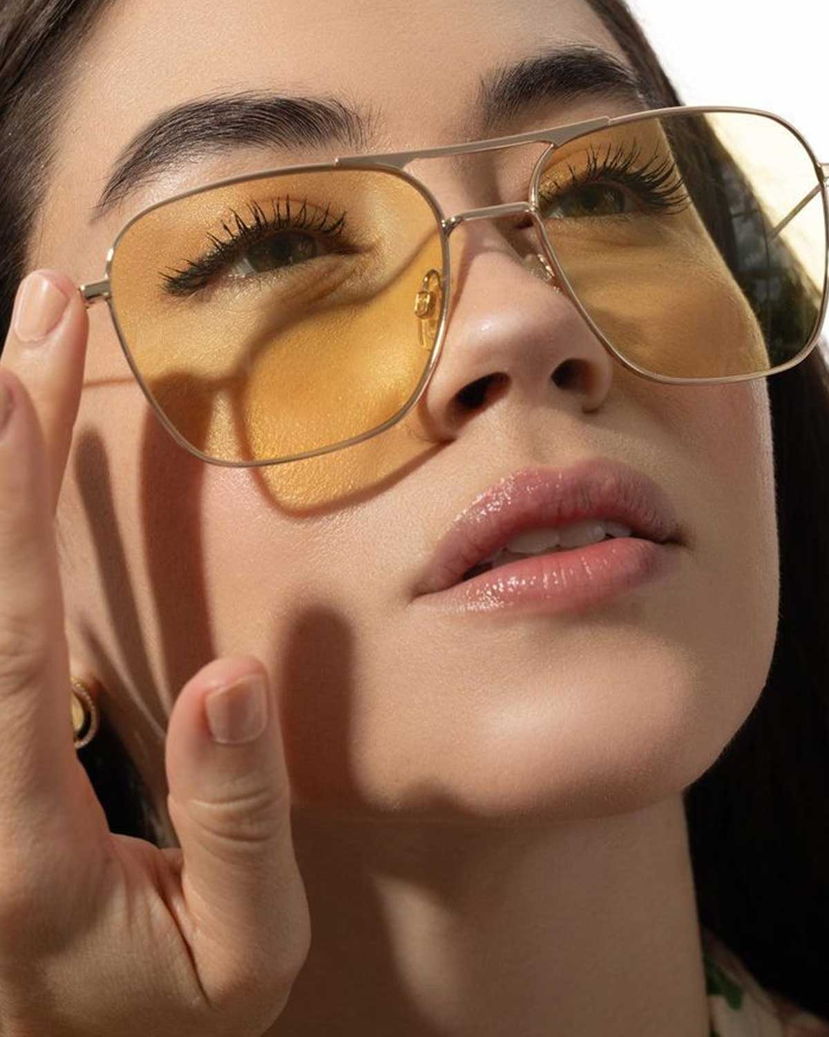 Adjusting slipping glasses on nose bridge illustrating weight imbalance and frame fit issues